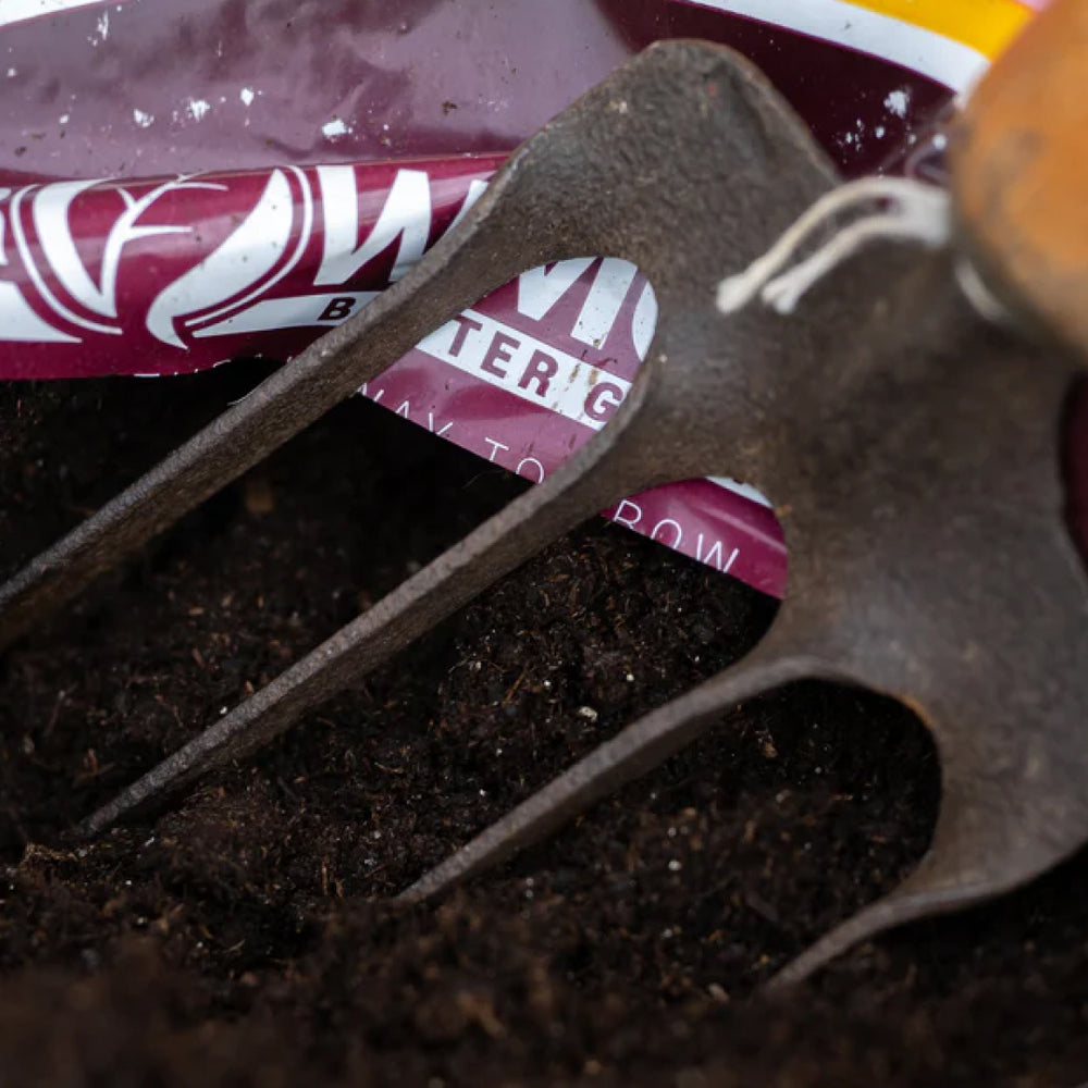 Close up image of a gardening fork in a bag of Growmoor Black Gold Organic compost