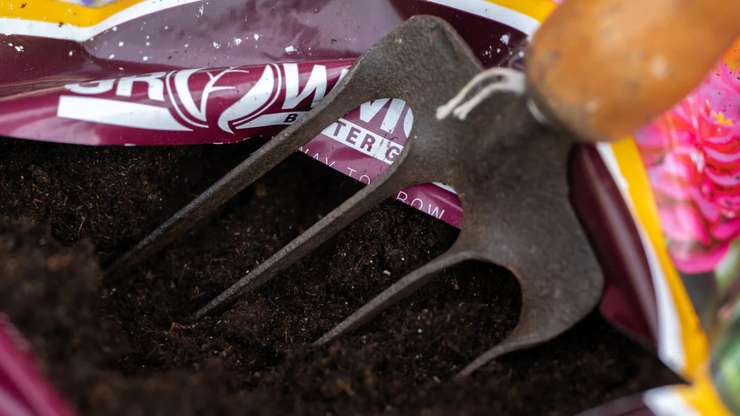 Close up image of a gardening fork in a bag of Growmoor Black Gold Organic compost